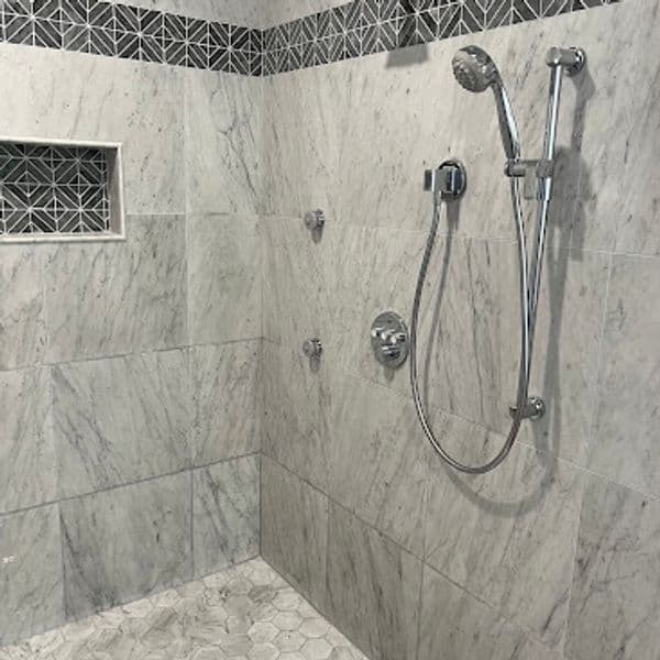 Modern marble shower design with geometric tile accents and chrome fixtures.