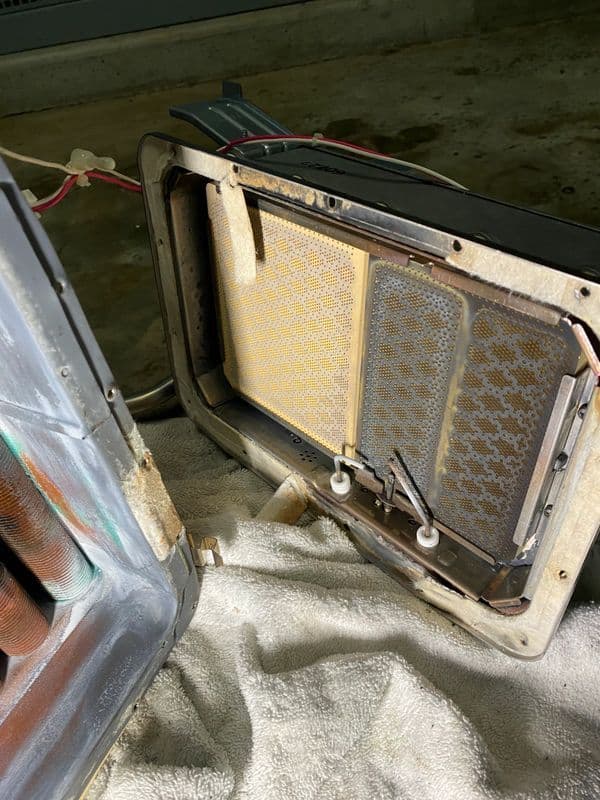 Disassembled microwave interior showing components and filters on a towel.