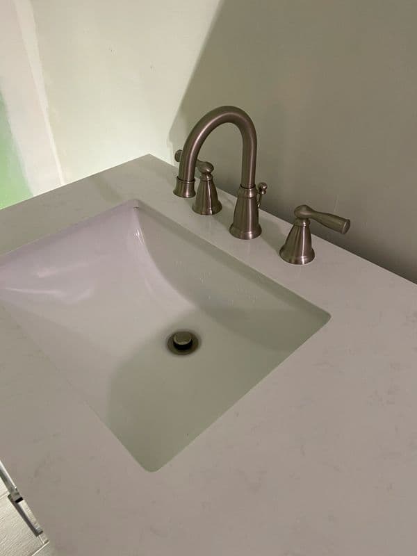 Modern bathroom sink with brushed nickel faucet and clean countertop. Ideal for home renovation.