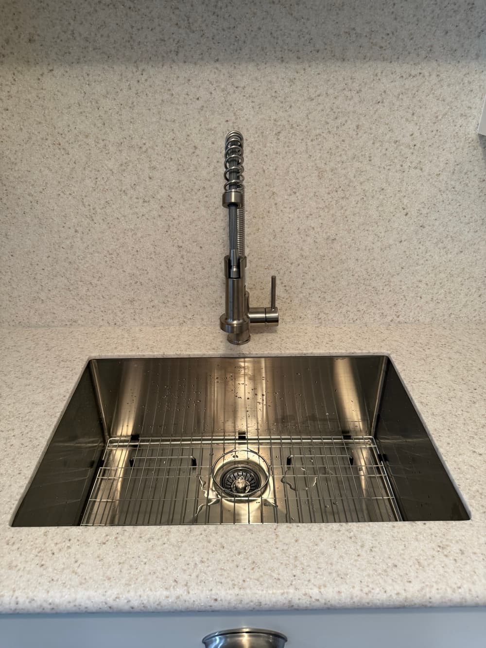 Modern kitchen sink with a stainless steel finish and pull-down faucet.